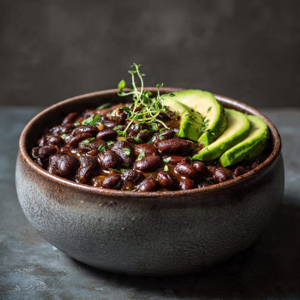 Braised black beans with avocado served as a grounding high-protein vegan meal