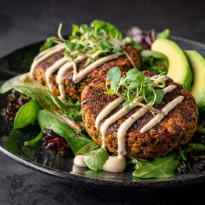 Lentil patties served with tahini sauce and fresh vegetables for a balanced plant-based meal